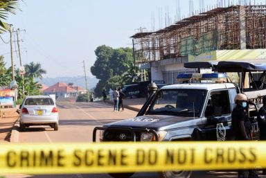 Ugandan police members secure the scene of an explosion in