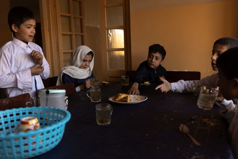 Samira, 9, and other children share tea and bread for