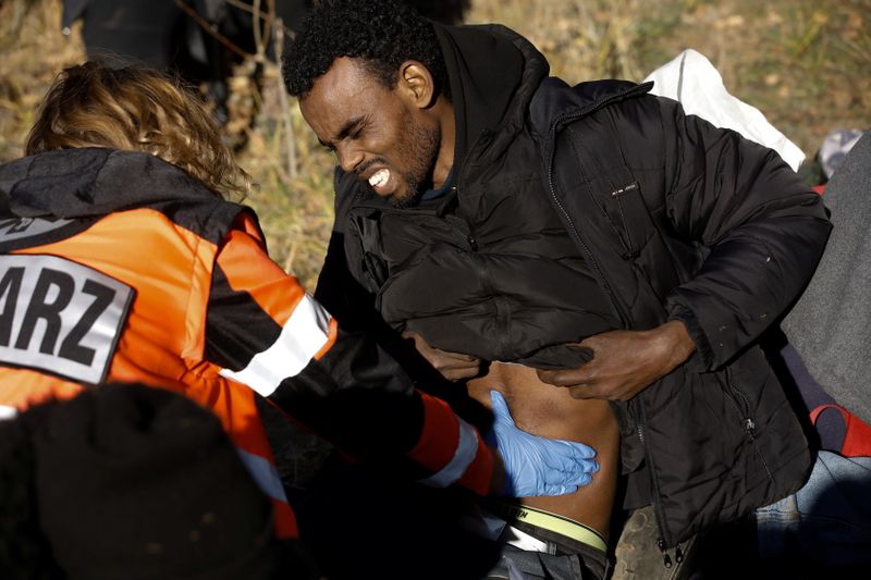 A migrant from Somalia is examined by a medical worker