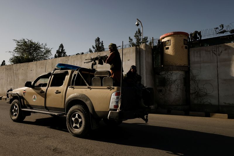 Taliban fighters patrol along a road in Kabul