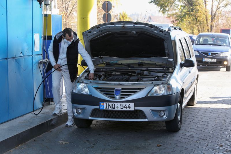 A man fills a car with natural gas at a
