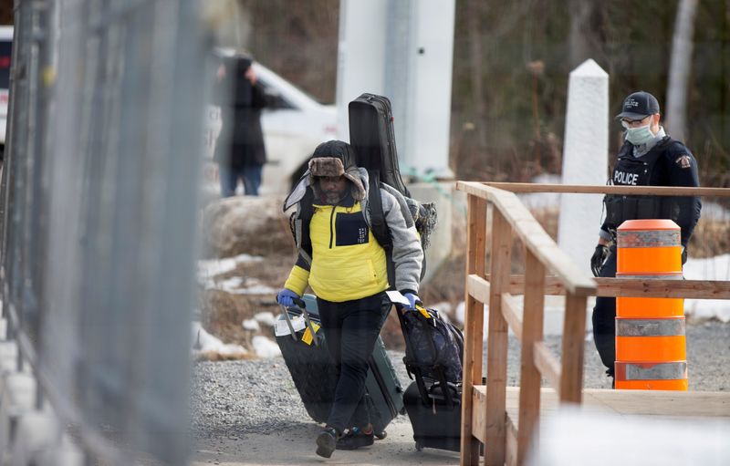 FILE PHOTO: An asylum seeker crosses the border from New