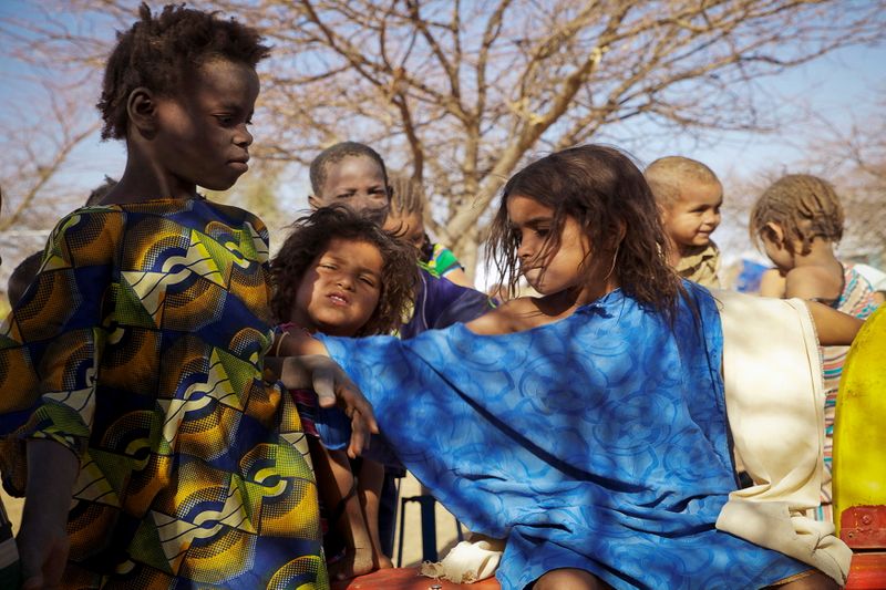FILE PHOTO: A Tuareg child pushes away a Bella girl