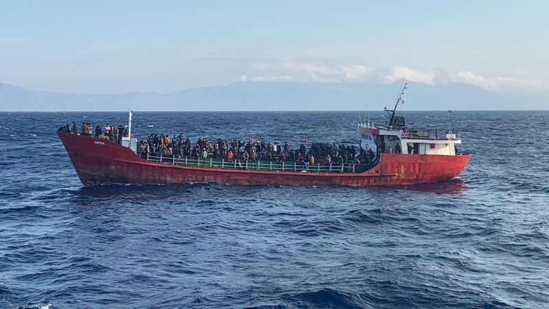 Cargo ship carries migrants during a rescue operation, as it