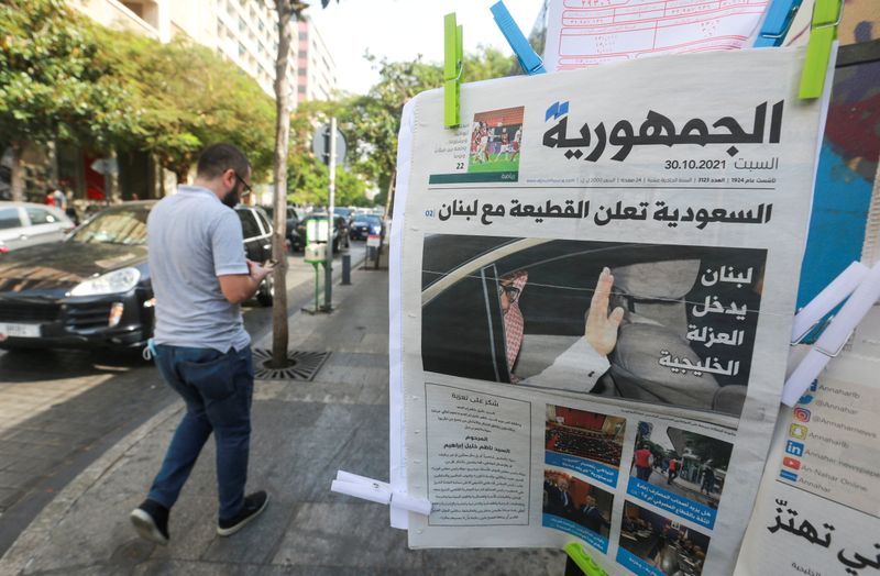 FILE PHOTO: Man walks near a newspaper with a headline