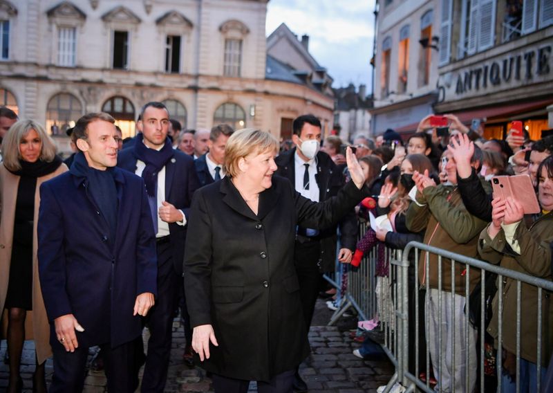 France’s President Emmanuel Macron, flanked by his wife Brigitte Macron,
