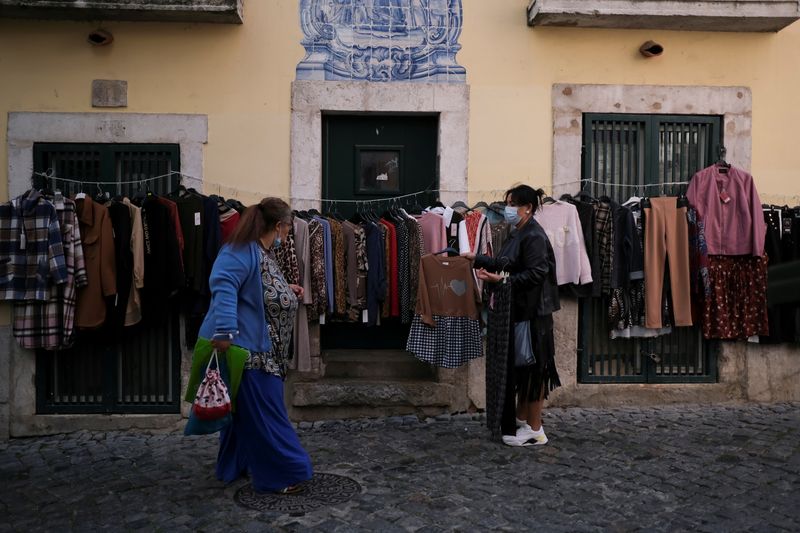 FILE PHOTO: A woman tries to sell clothes in the