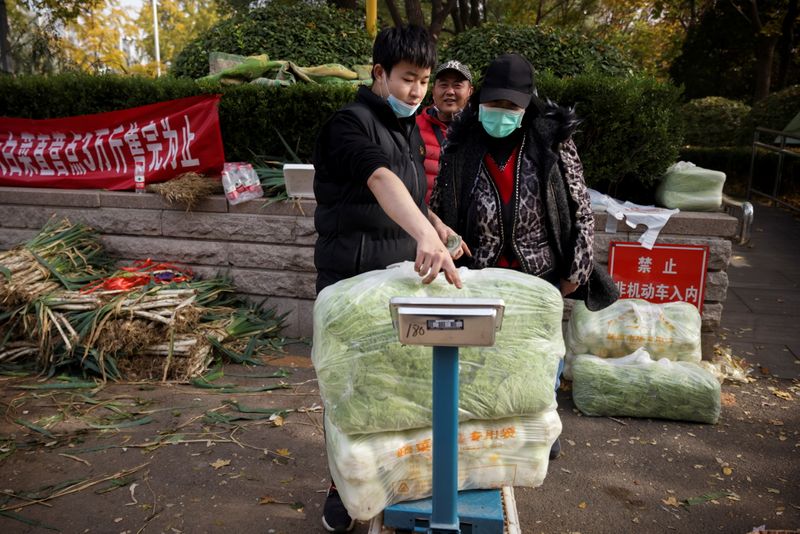 A woman buys cabbage at a street stall following outbreaks