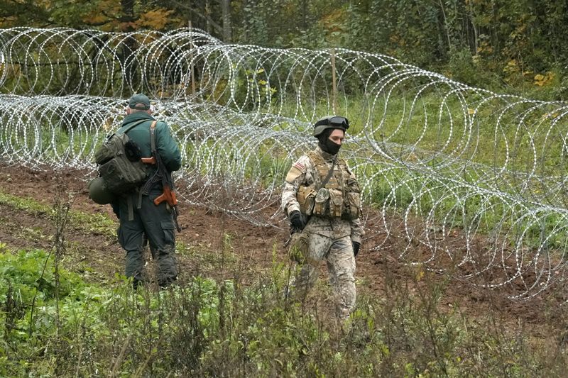 FILE PHOTO: A Latvian border guard and an army serviceman