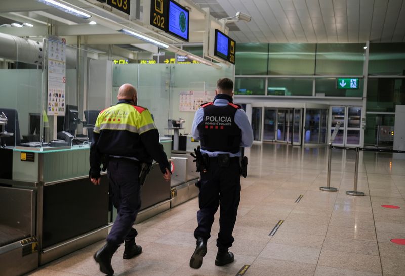 Police officers patrol at Josep Tarradellas Barcelona-El Prat Airport, in