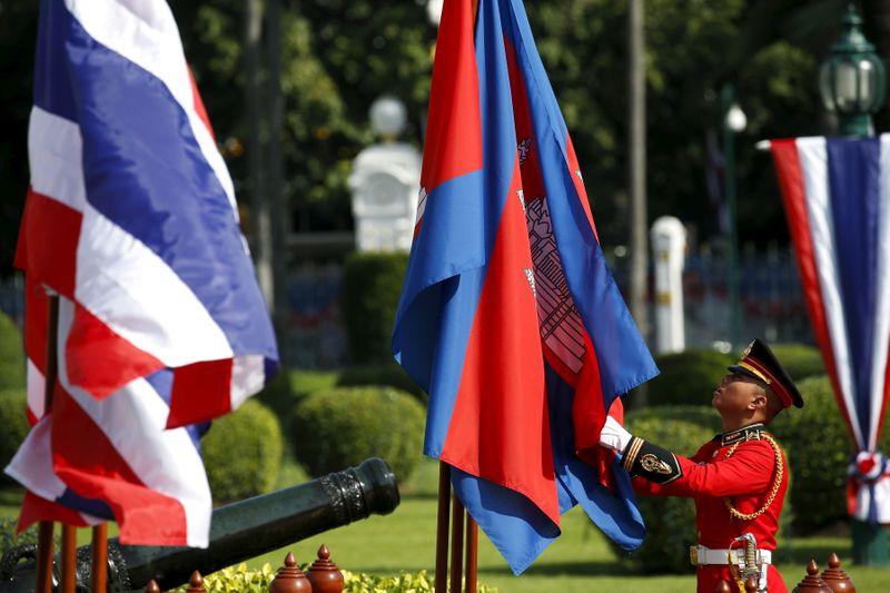 FILE PHOTO: An honour guard adjusts Cambodia’s national flags before