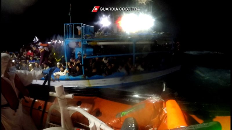 Italian coastguard rescue migrants from boat in distress in the