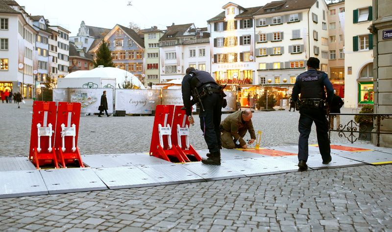 FILE PHOTO: Swiss police officers prepare mobile barriers blocking a