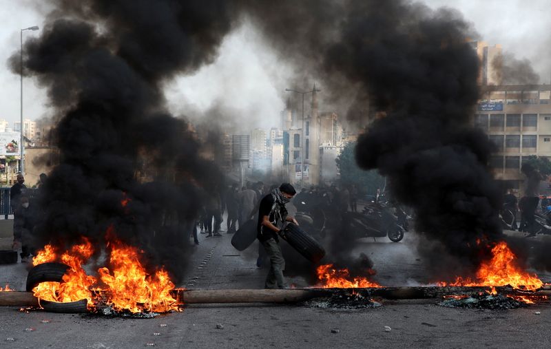Demonstrators block a road with burning tires during a protest