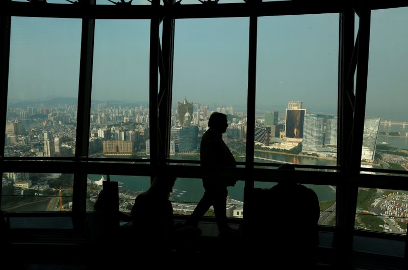 A visitor walks inside Macau Tower overlooking the skyline of