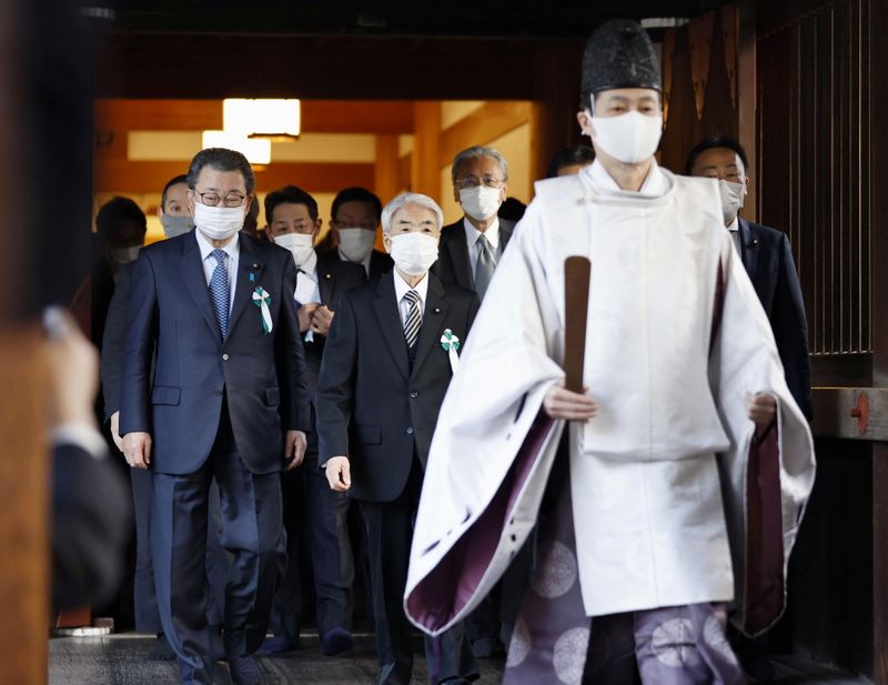 A Shinto priest accompanies a group of Japanese lawmakers as
