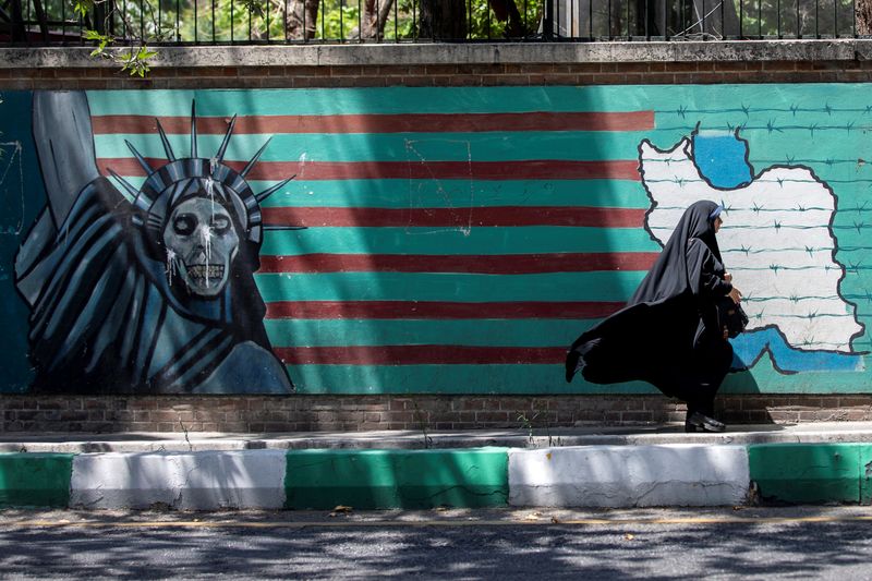A woman walks past the mural showing U.S. flag with