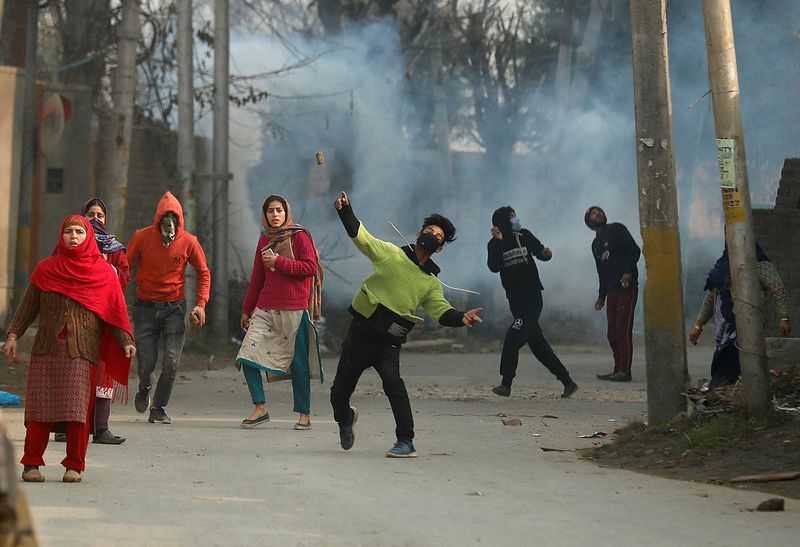 A demonstrator throws a stone towards Indian police during a