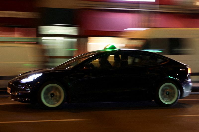 A man drives a Tesla taxi car in Paris