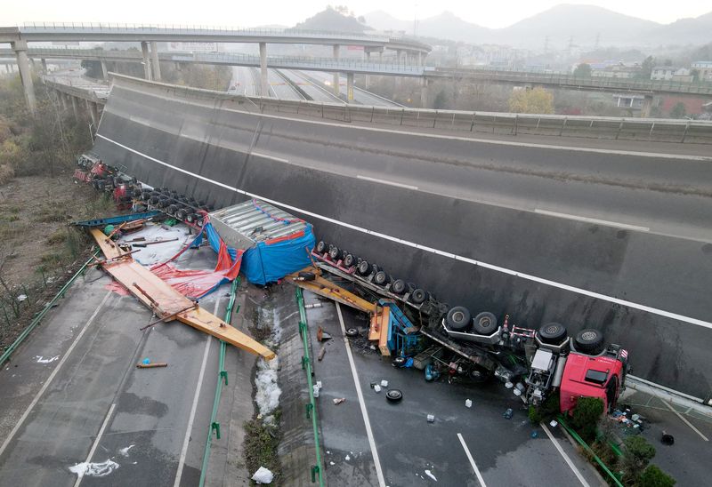 Overturned vehicles are seen at the site where a highway