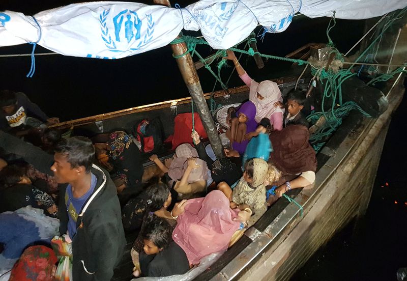 Rohingya refugees arrive by boat at a port in Lhokseumawe,