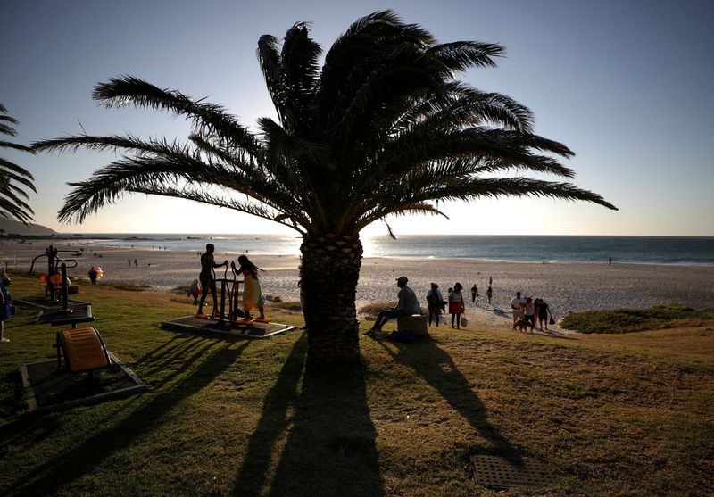 FILE PHOTO: Vistors take in the sunlight at Camps Bay