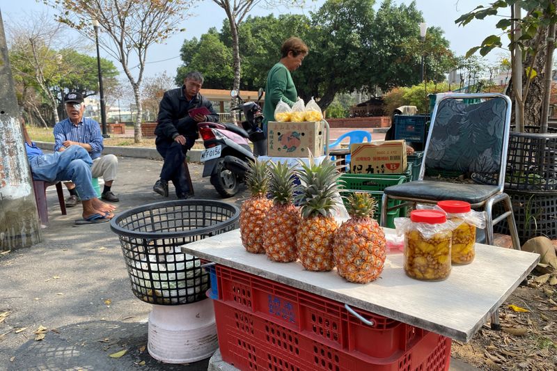 FILE PHOTO: Farmers sell pineapples at a stall by the