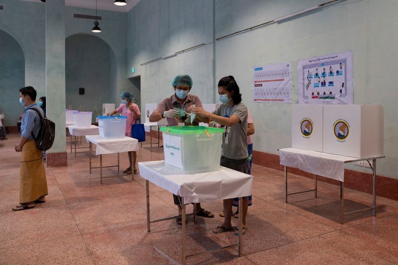 A woman wearing a protective face masks casts her ballot