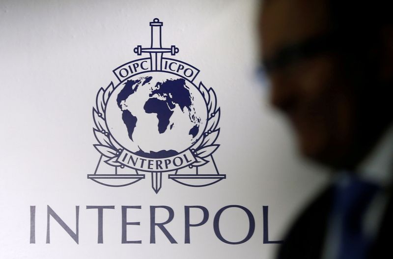 FILE PHOTO: A man passes an Interpol logo during the