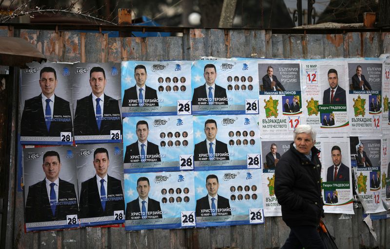 Woman walks past election posters of the ruling centre-right GERB
