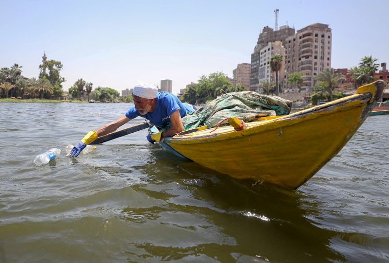 Fisherman Nasar uses his boat to collect plastic garbage from