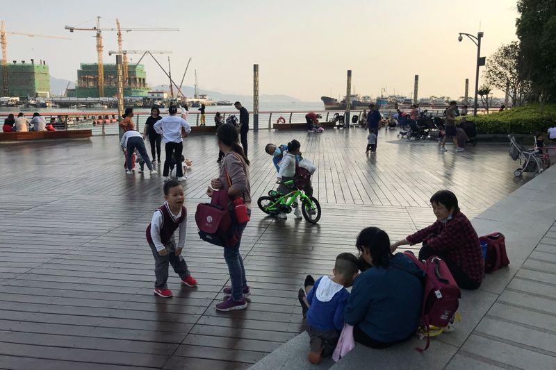 Children play at a waterfront in Shekou area of Shenzhen