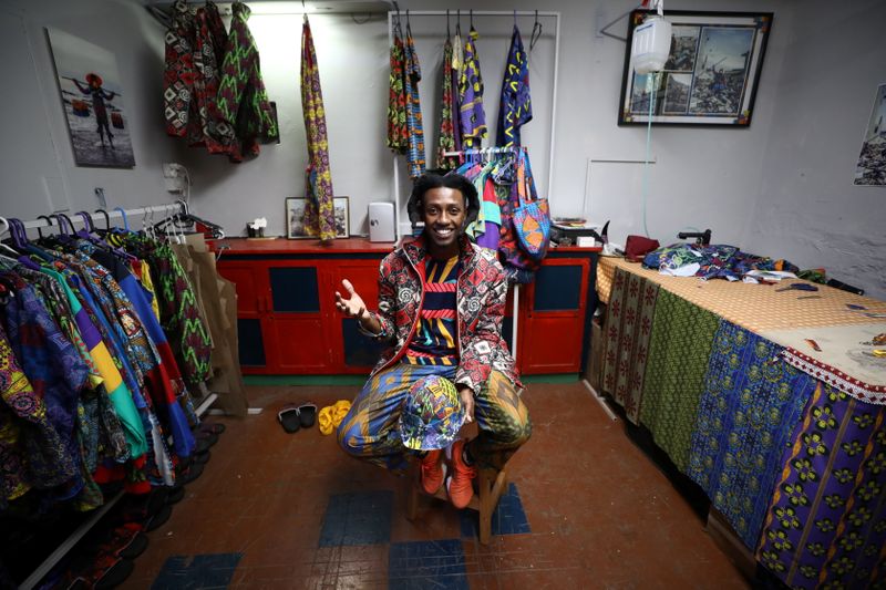 Rwandan-born fashion designer and visual artist Eli Gold sits amongst