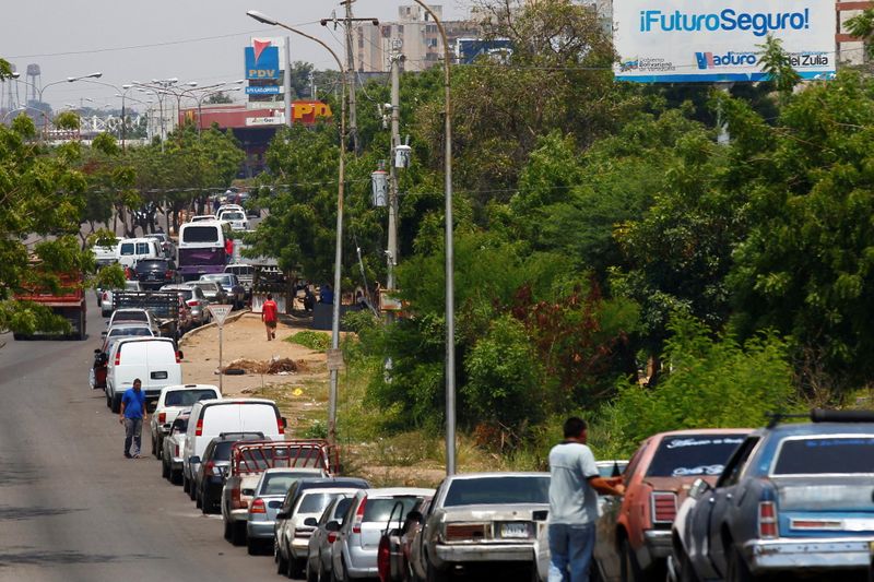FILE PHOTO: FILE PHOTO: People with vehicles wait in line