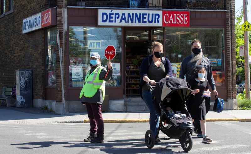 People pass a shop sign written in French in Montreal