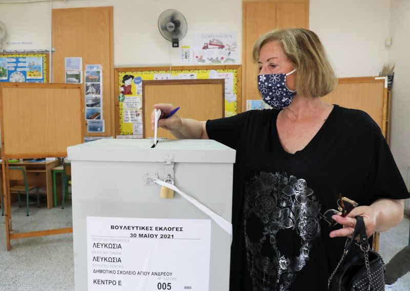 A woman casts her vote during parliamentary elections at a