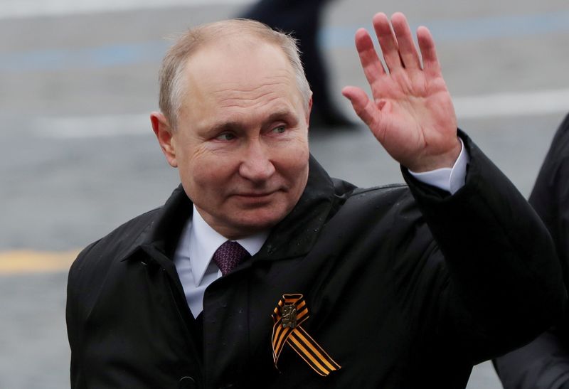 FILE PHOTO: Russian President Vladimir Putin waves while walking along