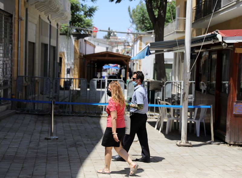 People walk next to the closed Ledra checkpoint of the