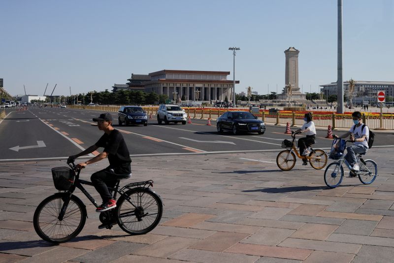 People cycle in Tiananmen Square in Beijing