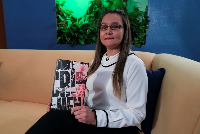 Linda Lopez holds her book “Double Crime” during an interview