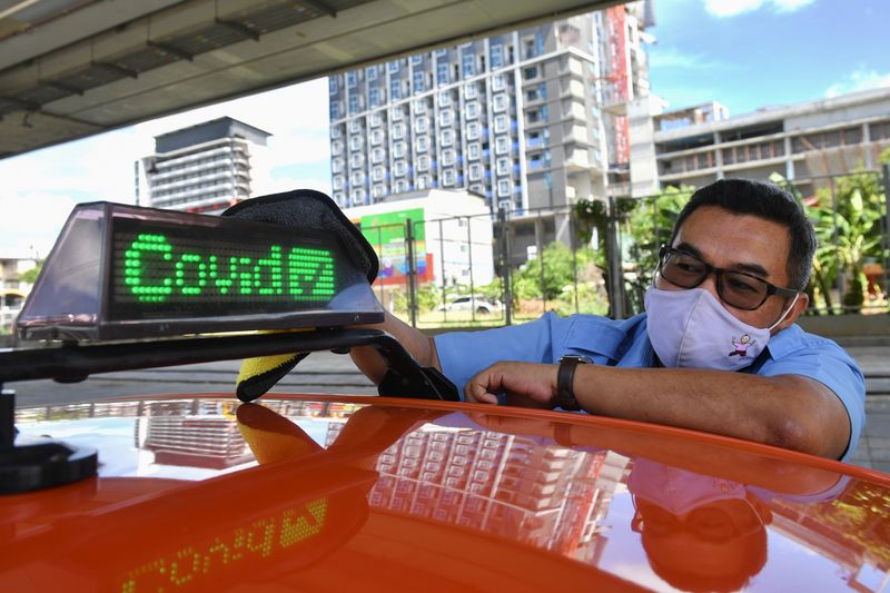 Thai taxi driver shows vaccination status on car to gain