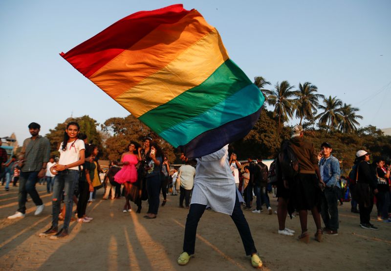 A participant waves a flag during Queer Azadi Pride, an