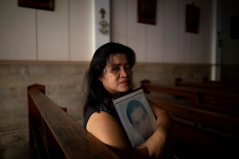 Normita Lopez, 56, is photographed while holding a portrait of