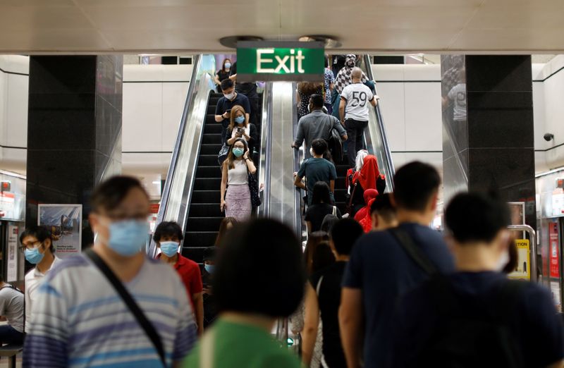 Commuters wearing protective face masks leave a station during the
