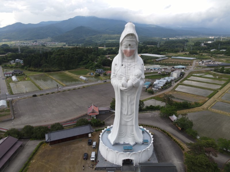 Drone picture shows a mask placed on a 57-metre-high statue