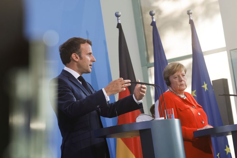 German Chancellor Angela Merkel and French President Emmanuel Macron give