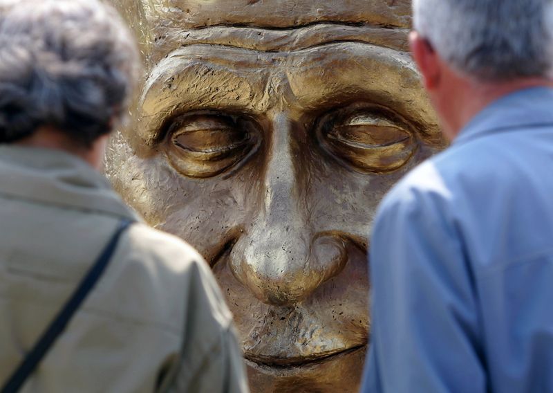FILE PHOTO: Elderly Romanians look at a sculpture of France’s
