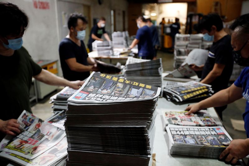 Workers prepare copies of Apple Daily newspaper at its printing