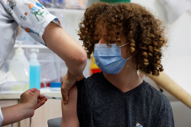 A teenager receives a dose of a vaccine against the