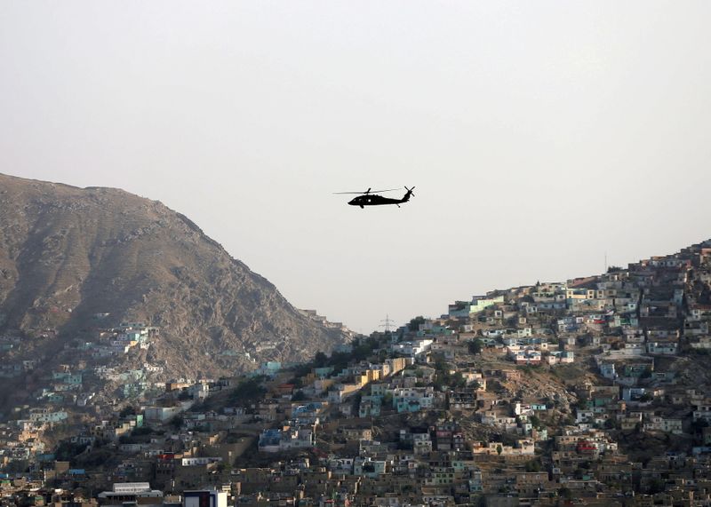 FILE PHOTO: A NATO helicopter flies over the city of